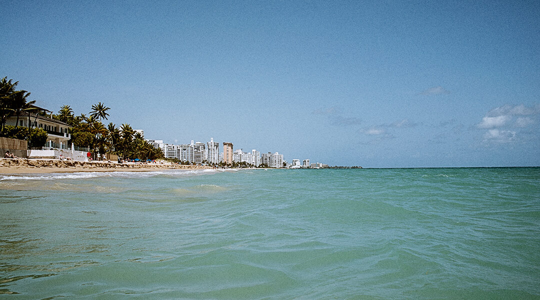 The turquoise waters of Ocean Park beach in Puerto Rico on a summer day.