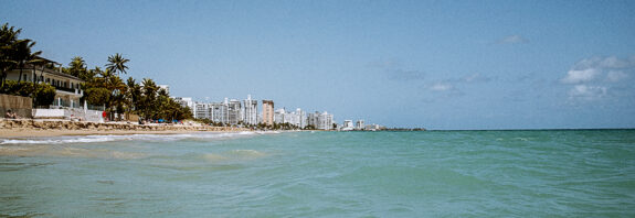 The turquoise waters of Ocean Park beach in Puerto Rico on a summer day.